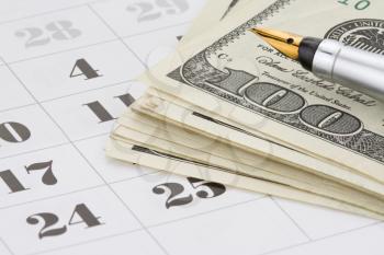ink pen and dollar money on calendar background