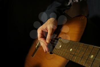 man playing classical guitar at night