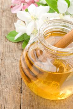 honey in glass jar on wood background