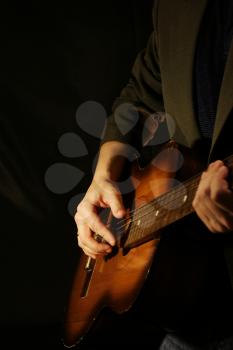 man and guitar at black background