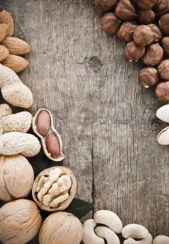 variety of nuts on wood background