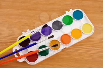 painters palette with brush on wooden texture