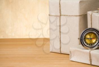parcel wrapped and compass on wood background texture
