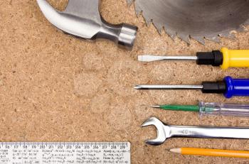 hammer, screwdriver, wrench and other tools and instruments on wood texture