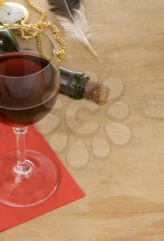 glass of red wine and bottle on wood background