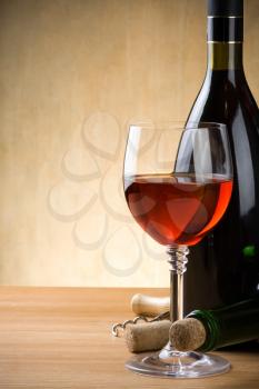 glass and bottle of wine on wood background
