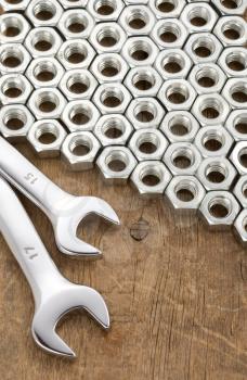 metal nuts tool and wrenches on wood background