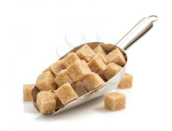 brown sugar cubes in scoop isolated on white background