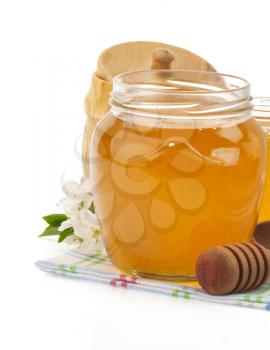 glass jar full of honey and stick isolated on white background