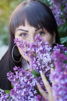 young woman and lilac outdoors