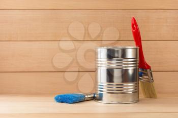 paint bucket and paintbrush  on wooden background
