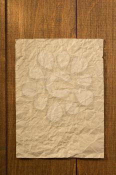 wrinkled note paper on wooden background