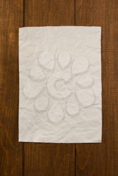 wrinkled note paper on wooden background