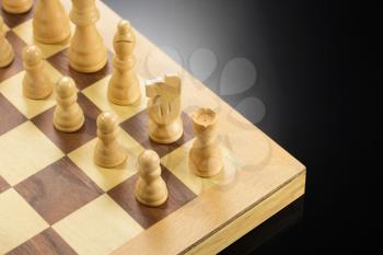 chess figures and board at black background