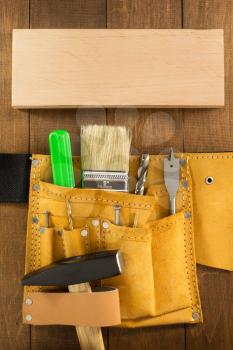 tools and instruments in belt on wooden background