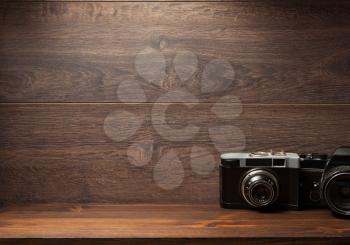 old camera at shelf wall wooden background texture