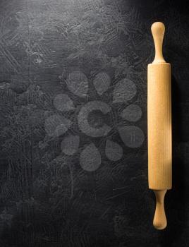 rolling pin at black background texture
