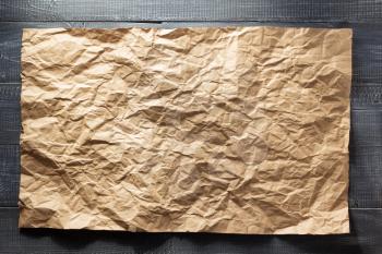 wrinkled paper at wooden background