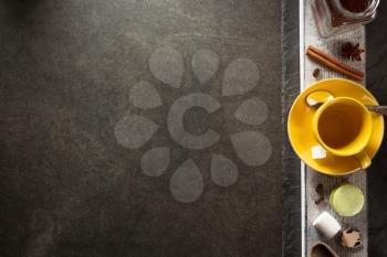 cup of coffee and ingredients on table background