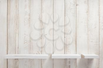 set of wooden shelves on white wall background texture