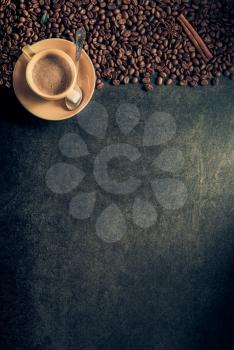 cup of coffee and beans on table background, top view