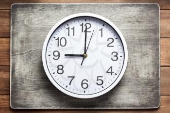 wall clock at wooden background texture