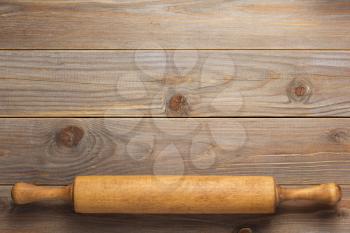 rolling pin at wooden board rustic plank table background, top view