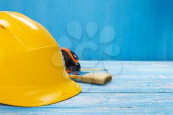 construction helmet and tools on wooden table background texture