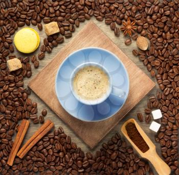 cup of coffee and beans on wooden background, top view