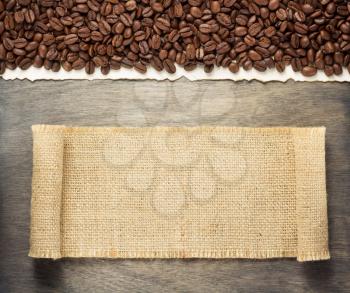 hessian burlap sack and coffee beans on wooden background, top view