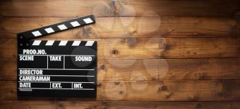 movie clapper board at wooden background texture, top view