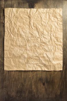 wrinkled paper at wooden surface background