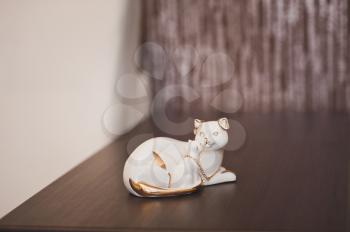 Figurine in the form of a lying cat with wedding rings.