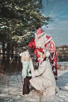 Santa Claus hands over gifts to the child.