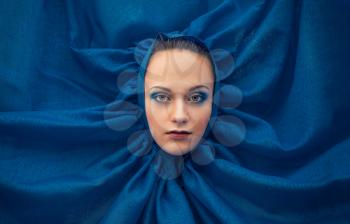 Woman's face in a dark blue fabric.