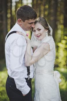 Newlyweds kissing on the background of the forest.