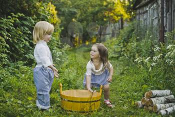 Girl and boy playing outdoors with soap bubbles.