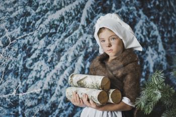 Little girl collects in the winter forest wood.
