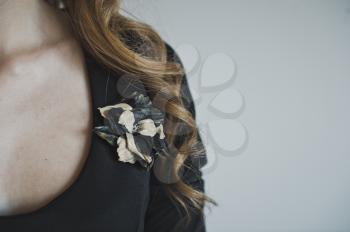 The decoration on the dress in the shape of a flower.