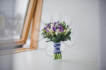 Bouquet lying in curtains on a window sill.