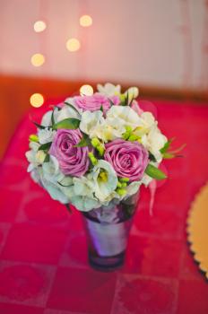 Bouquet from roses and other flowers on a table.