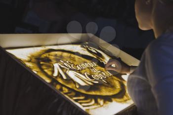 Sand painting on a light table.