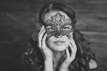 Portrait of a girl in a black masquerade mask.