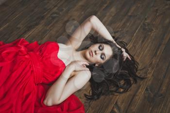 Portrait of a girl lying on a wooden floor.