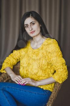 Portrait of a girl with long hair in yellow shirt.