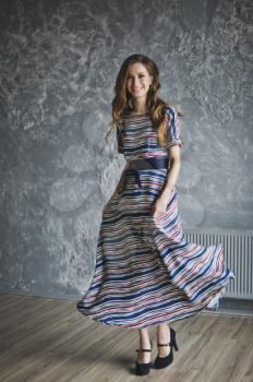 Portrait of a girl in a long striped dress.