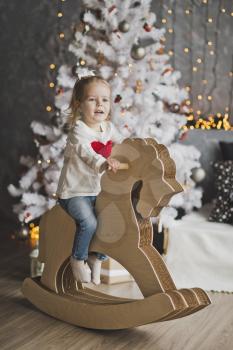 Little girl riding a toy horse 7074.