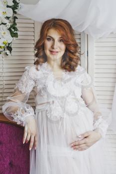 Portrait of a redhead girl in a transparent negligee.