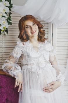 Portrait of a redhead girl in a transparent negligee.