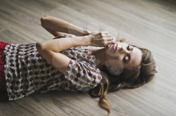 The girl in a fit of tenderness lying on the floor.